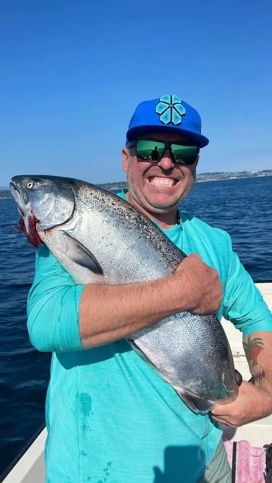 Angler with chinook under blue sky